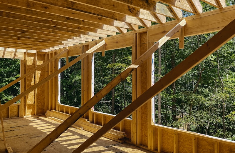 Sunroom addition framing with large window openings overlooking trees