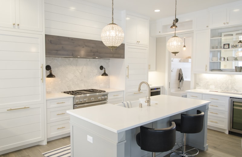 White shaker-style kitchen with a shiplap range hood and blue island