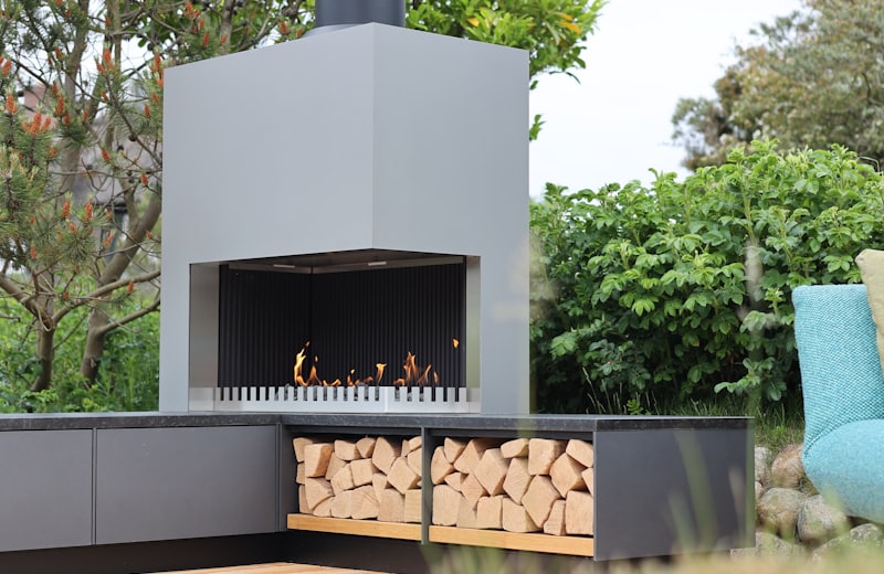 Modern freestanding outdoor fireplace on a wood deck